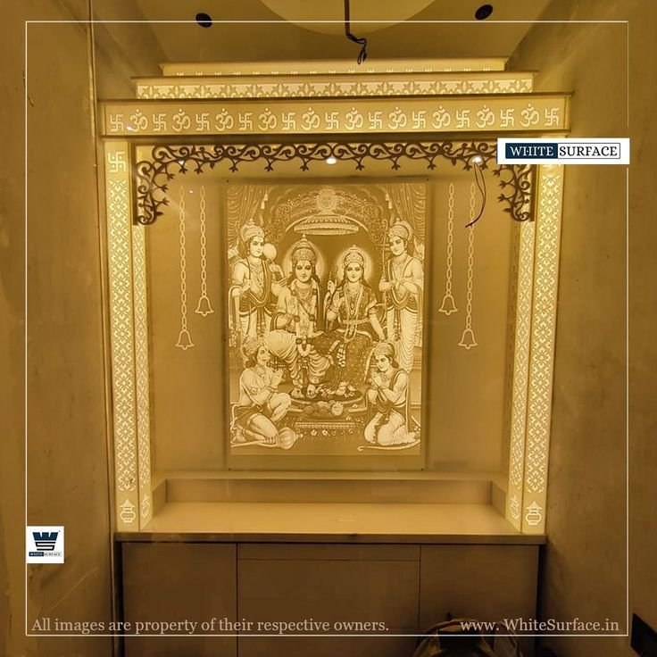 Backlit solid surface Corian mandir design featuring an illuminated Ram Darbar engraving, decorative border jali work, and lower storage cabinets for a modern home pooja room.